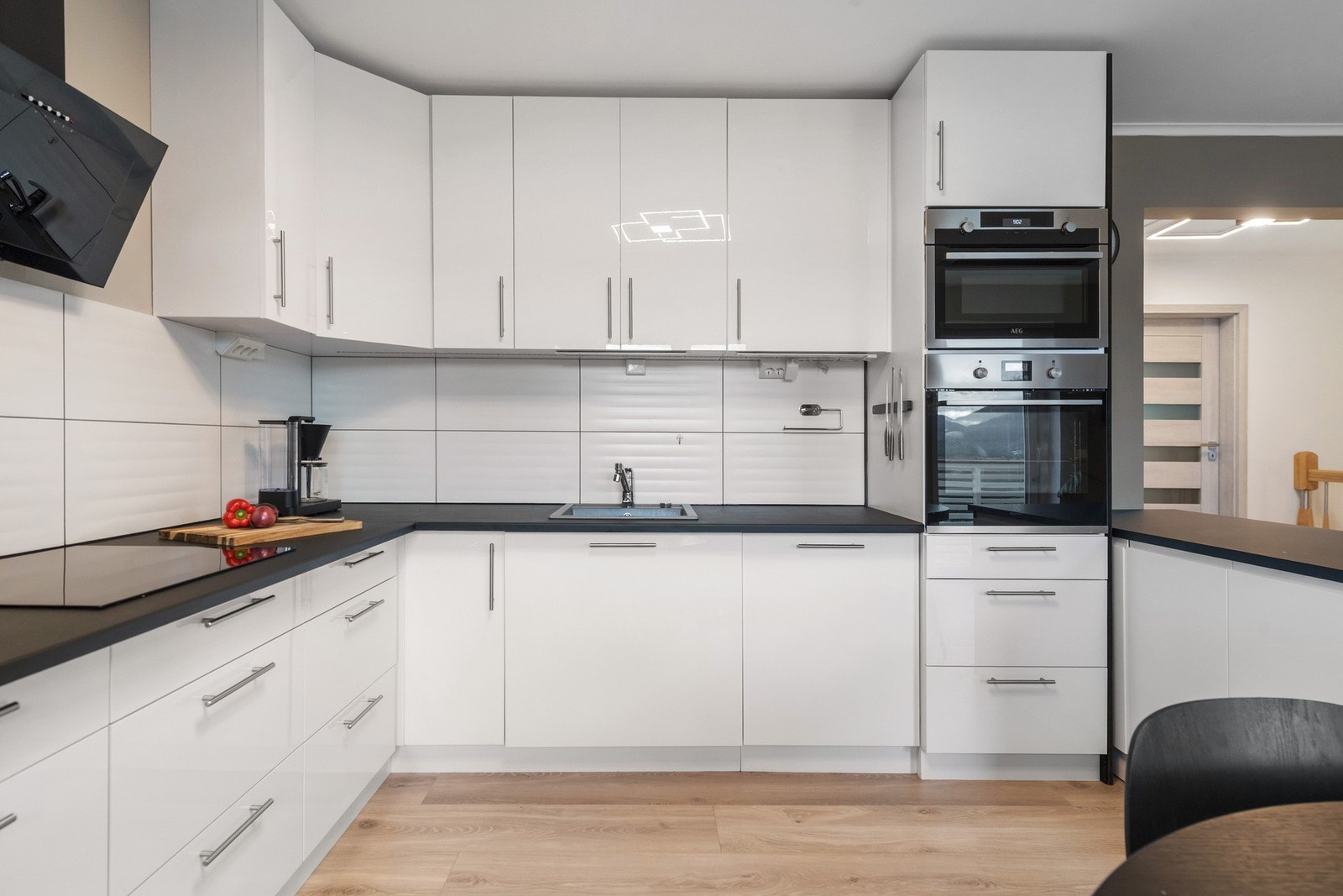 Kjøkkeninnredningen har glatte fronter i høyglans og laminat benkeplate. Galleribilde