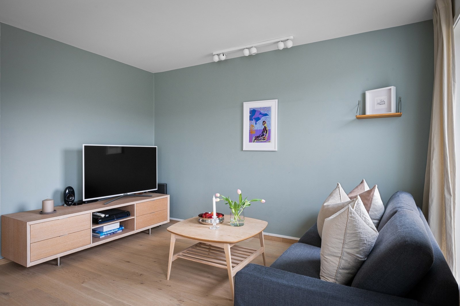 Praktisk innhukk i stuen for tv-stue som da er skjermet fra siden med kjøkkenet. Delikat malt opp, lekker 1-stavs gulv fra Skau gulv og naturlig lys med fantastisk utsikt. Galleribilde