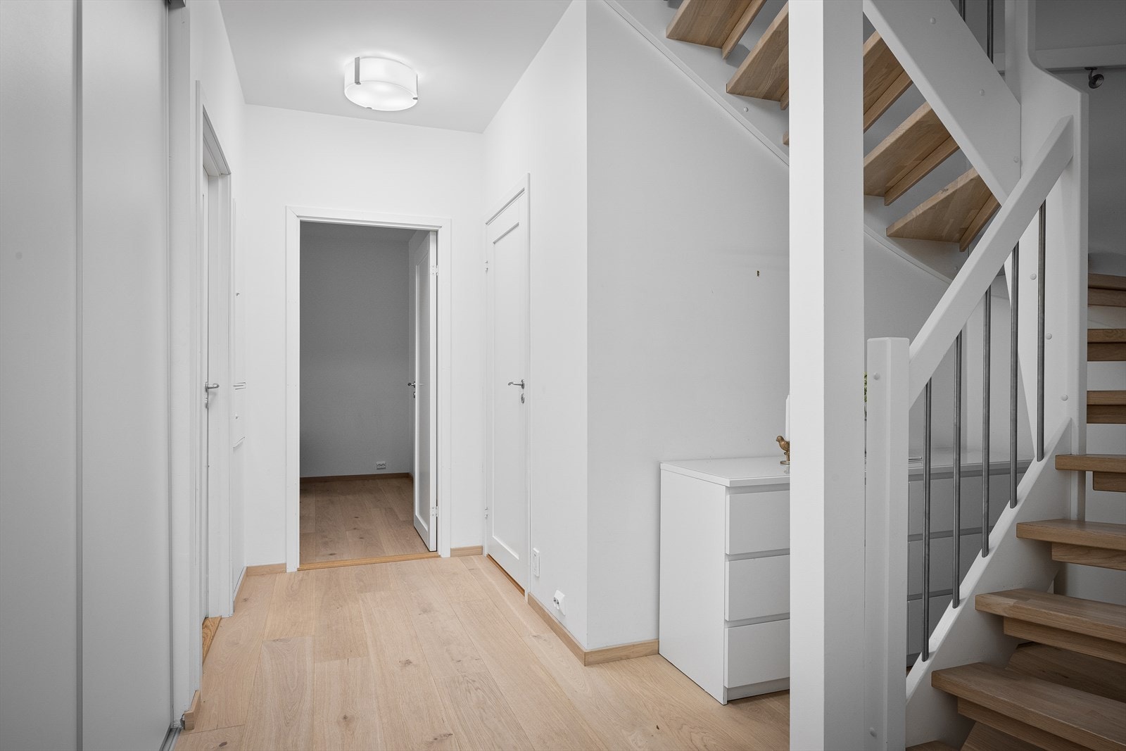 Hall med skyvedørsgarderobe og god plass til kommoder under trapp. 1-stavs parkett eik live pure fra Skau gulv. Galleribilde