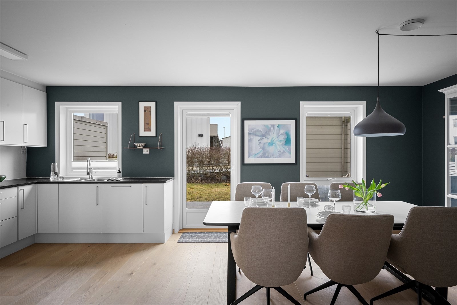 Optimalt oppsatt kjøkken for maksimal oppbevaring, funksjonalitet og bespisning. Spotter under overskap. Rikelig med naturlig lys via vinduer og terrassedør. Stilrent og enkelt å tilføre eget interiør. Galleribilde