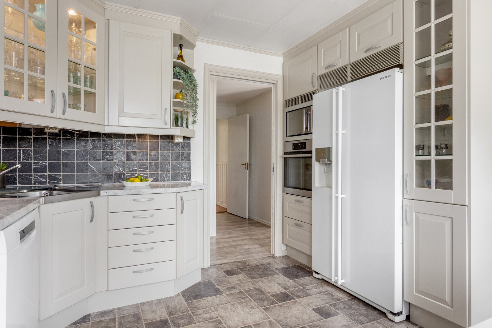 Videre er innredningen utstyrt med integrert stekeovn og mikrobølgeovn i høyskap, opplegg for oppvaskmaskin og nisje til side-by-side kjøleskap. Galleribilde