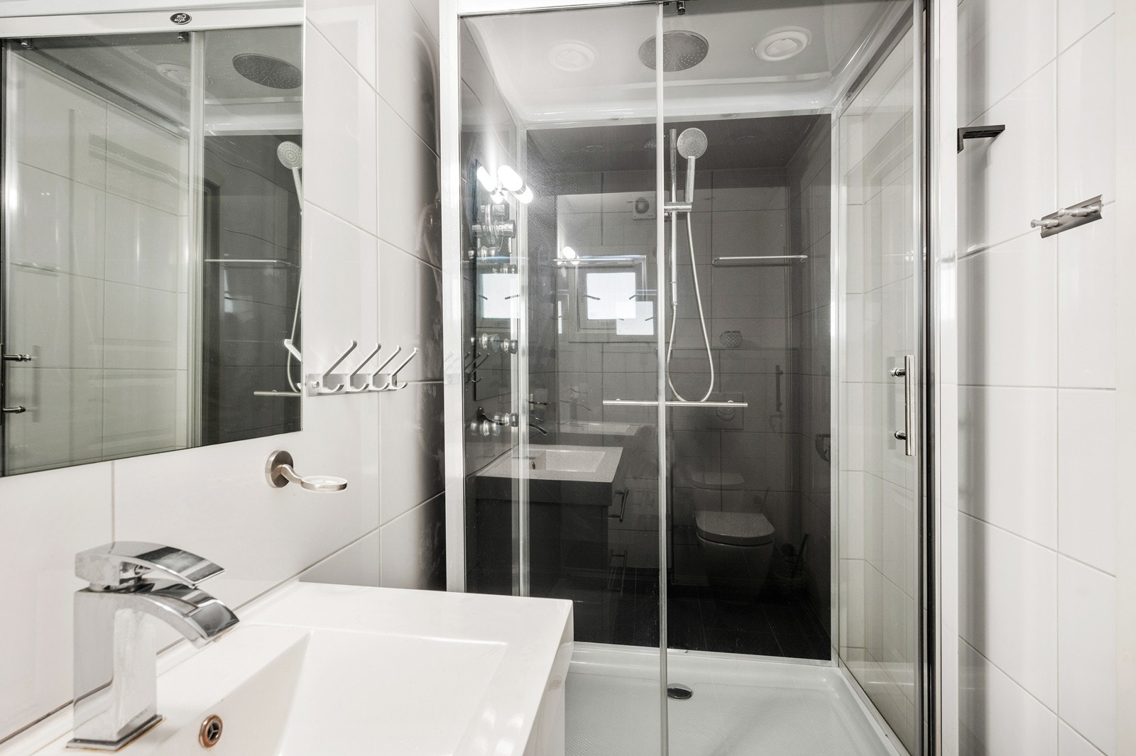 Badet i underetasjen har dusjkabinett med hånddusj, dyser og regndusj, samt vegghengt servantskap med skuffer. Ovenpåliggende servant med ett-greps armatur. Galleribilde