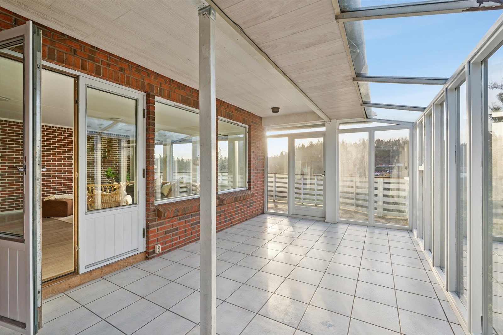 Innglasset balkong med flislagt gulv og store vindusflater gir et lyst uterom. Taket har gjennomskinnelige plater, hvor lekkasjer er registrert (kilde: tilstandsrapport). Galleribilde