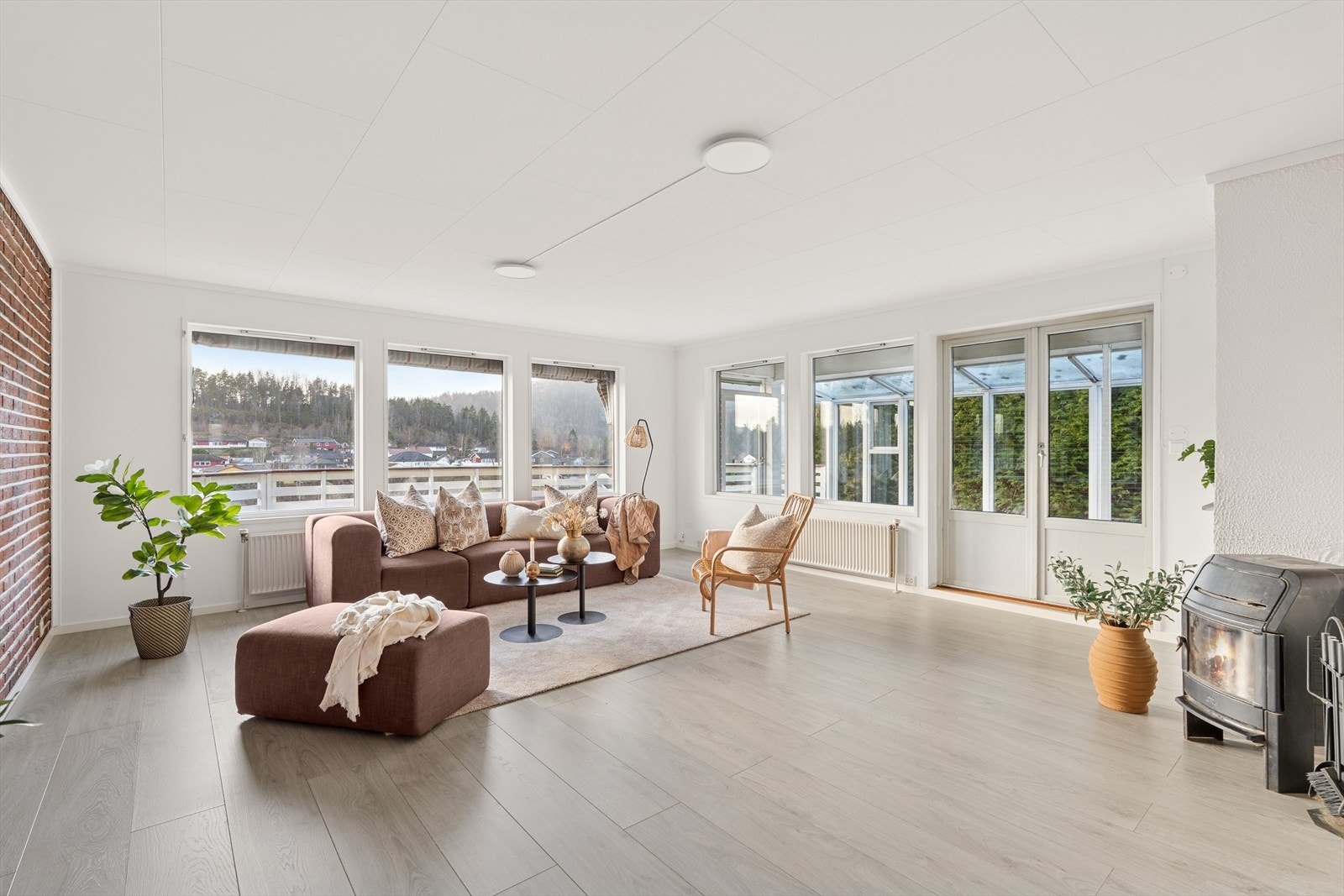 Store vinduer gir godt lysinnslipp i stuen, og vedovn bidrar til en lun atmosfære. Galleribilde