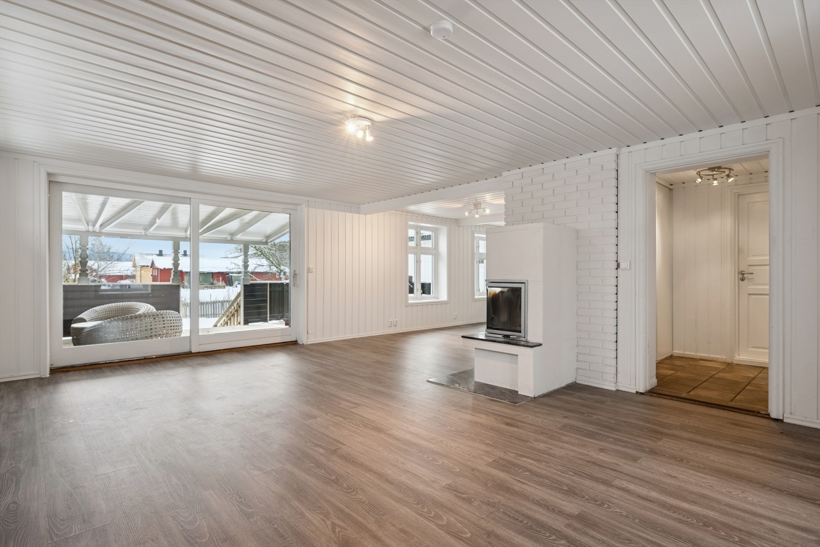 Lys og romslig stue med store vindusflater, peis med innsats og utgang til terrasse. Galleribilde
