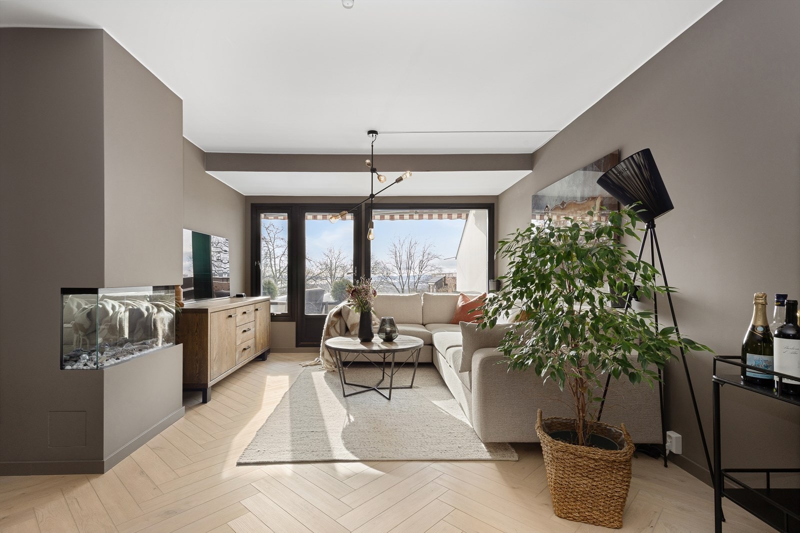 De store vinduene gir flott utsyn og sollys inn i rommet. En moderne peis (elektrisk) bidrar til lun stemning på kalde kvelder. Her er det god plass til en komfortabel sofagruppe og lesehjørne. Galleribilde