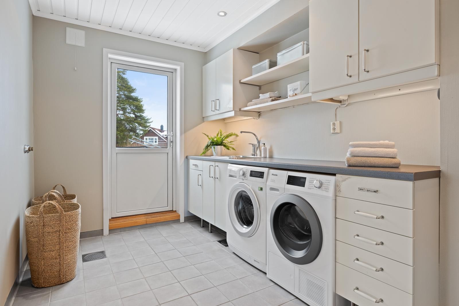 Romslig og praktisk vaskerom i 1. etasje med god innredning og utgang til terreng Galleribilde