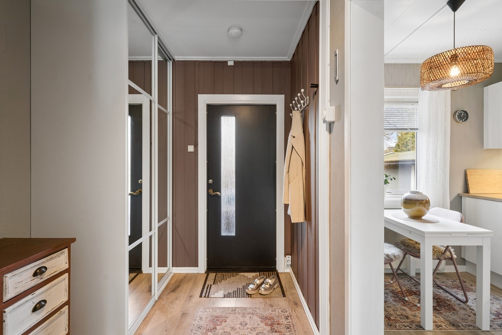 Lys og moderne entré med praktisk planløsning. En stor skyvedørsgarderobe med speilfronter og innredning gir både rikelig oppbevaringsplass og en følelse av økt romstørrelse. Galleribilde