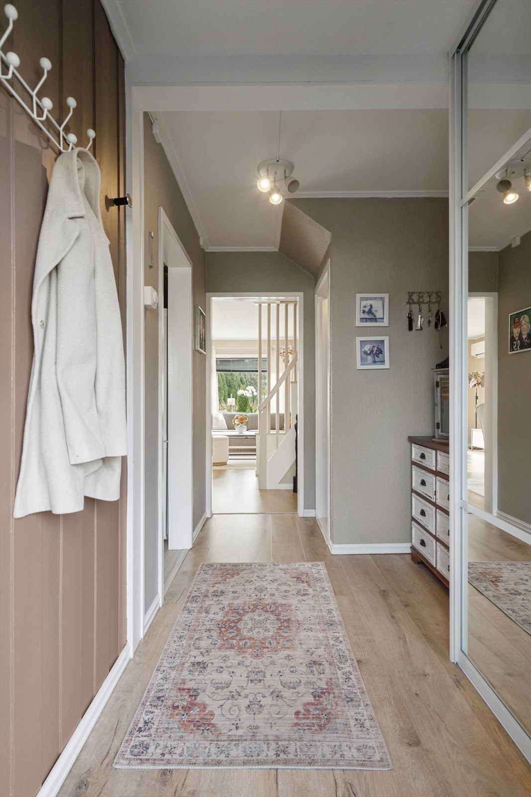 Lys og innbydende gang med god plass og en praktisk planløsning. Kjøkken til venstre, stue m/trapp til andre etasje rett frem og trapp til kjller til høyre i gangen Galleribilde