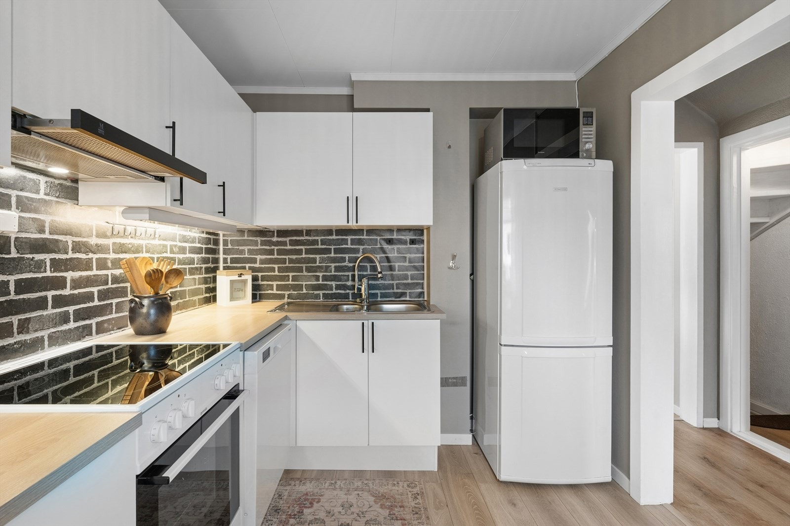 Klassisk innredning gir tidløst uttrykk, mens den mørke mursteinspregede veggen gir rommet karakter og et eksklusivt preg Galleribilde