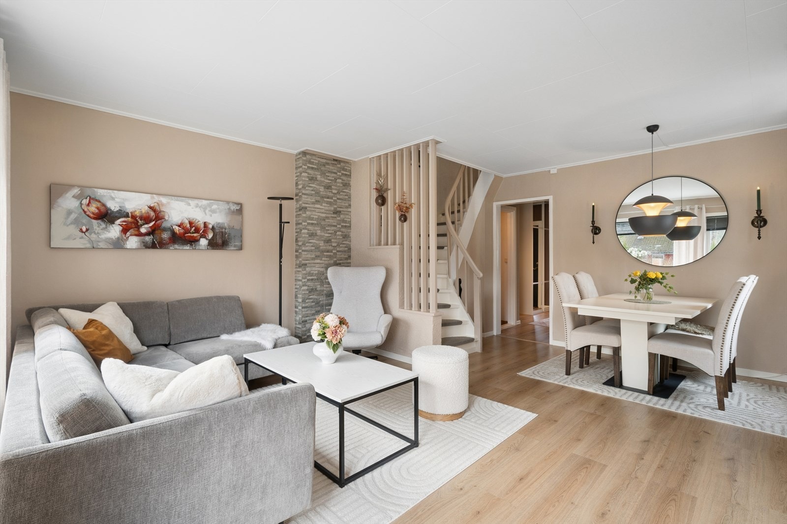 Lys og innbydende stue med åpen løsning mot spiseområdet. De lyse gulvene og den dempede fargepaletten gir rommet et moderne og harmonisk uttrykk Galleribilde