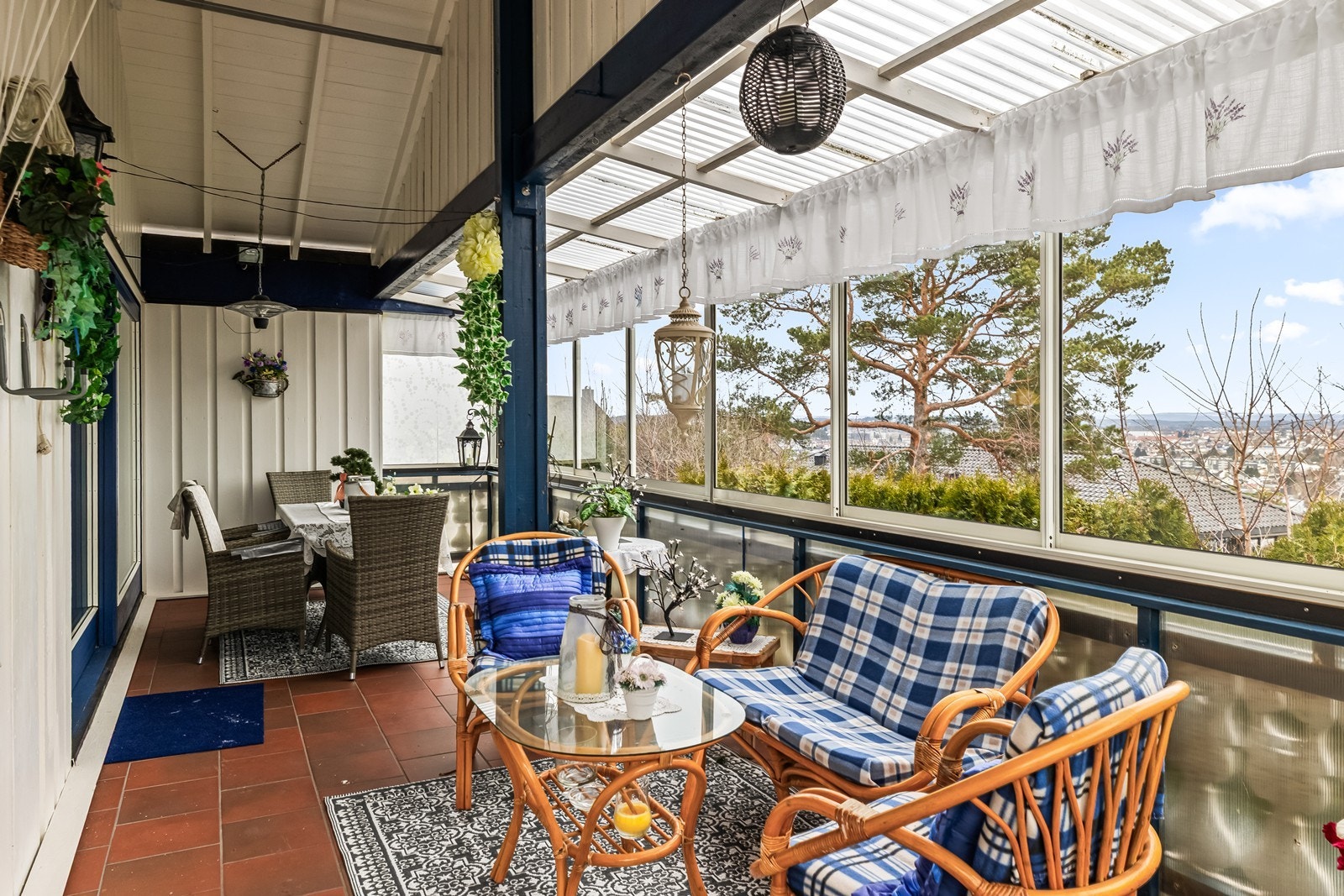 Innglasset balkong med flislagt gulv og glassfelt gir en lys og skjermet uteplass. Galleribilde