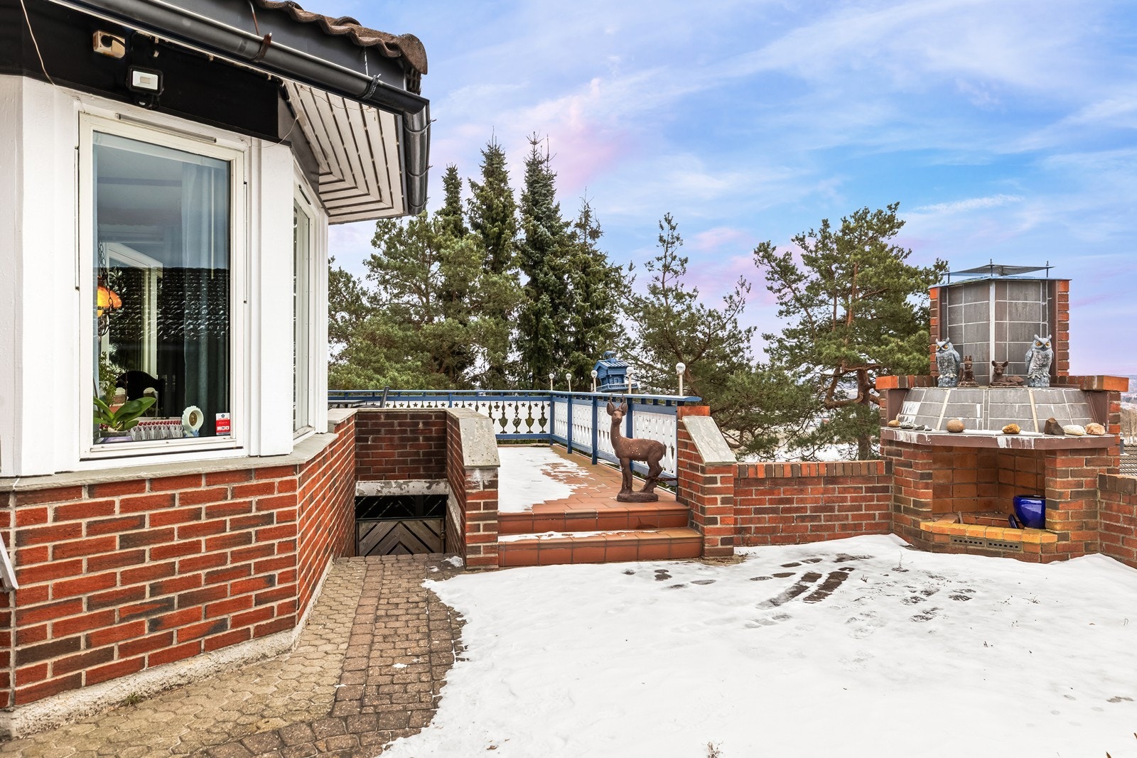 Flislagt uteplass med murt utepeis gir et koselig uteområde. Galleribilde