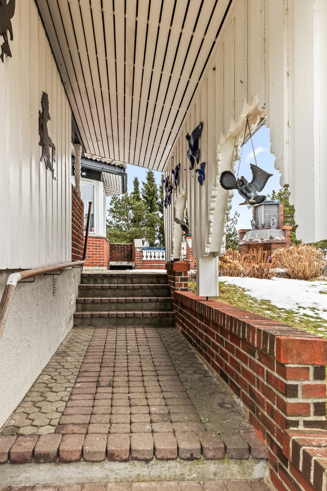 Overbygget inngangsparti med murte detaljer gir et solid førsteinntrykk. Galleribilde