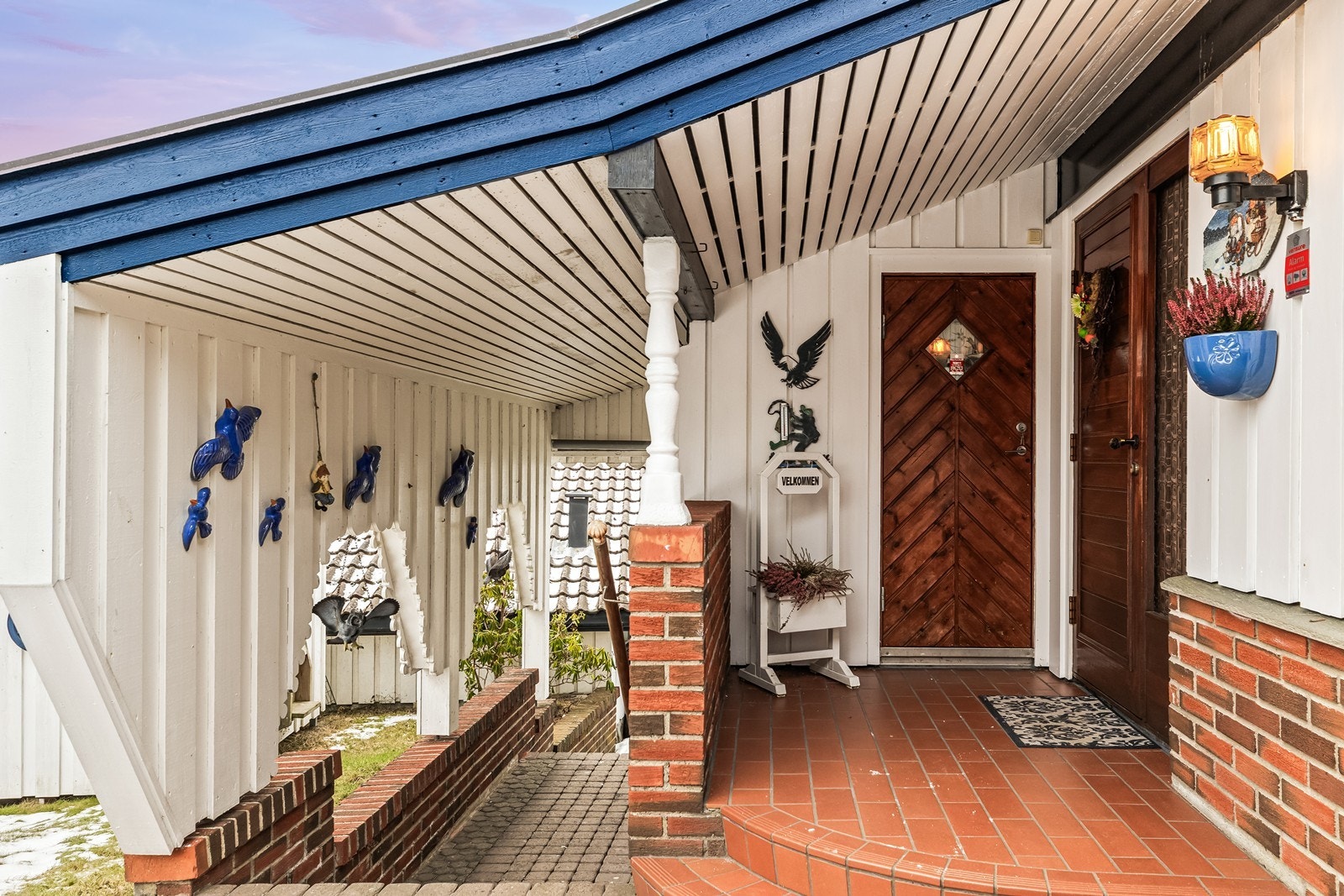 Inngangspartiet har flislagt gulv og tekket overbygg, som gir god beskyttelse mot vær og vind. Galleribilde