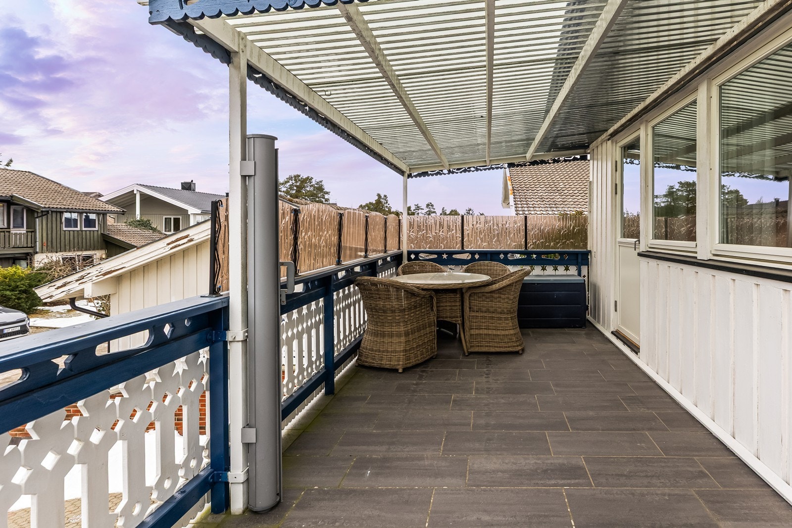 Overbygget balkong med flislagt gulv gir skjermet uteplass. Galleribilde