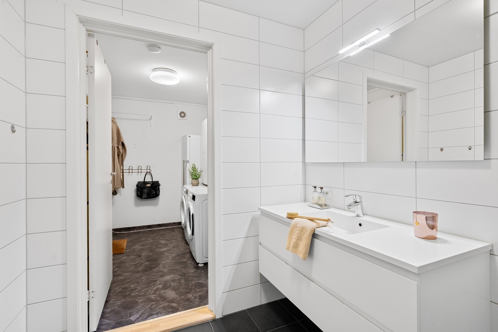 praktisk vaskerom med vinylgulv, sluk og opplegg for vaskemaskin/tørketrommel Galleribilde