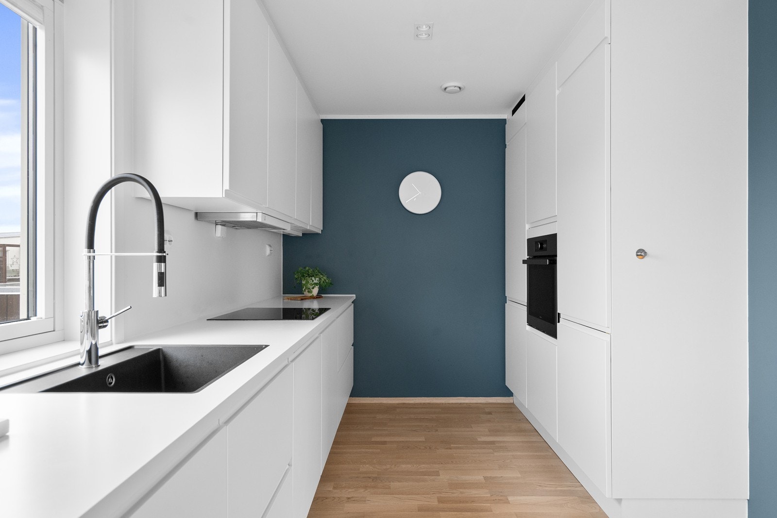 Tidløst kjøkken med hvite fronter og benkeplate. God skapplass og integrerte hvitevarer Galleribilde