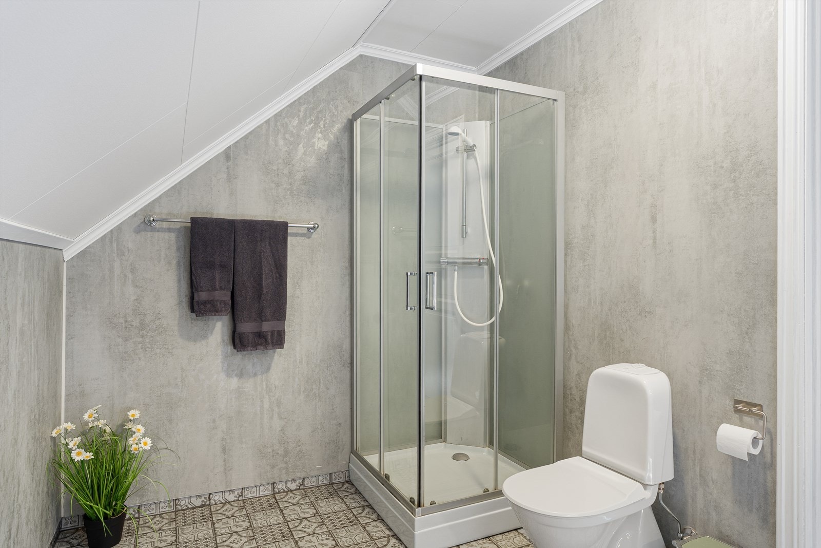 Badet på loftet ble oppgradert i 2021 med ny folie på veggene og selvklebende vinylfliser på gulvet - folien er lagt utenpå eksisterende baderomsplater og opprinnelig gulvbelegg ligger under vinylflisene Galleribilde