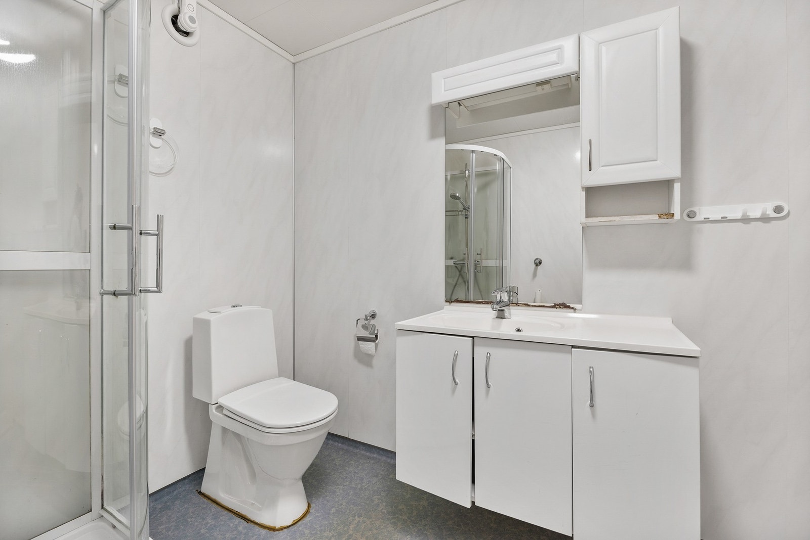 Badet er innredet med dusjkabinett, toalett og hvis baderomsinnredning Galleribilde