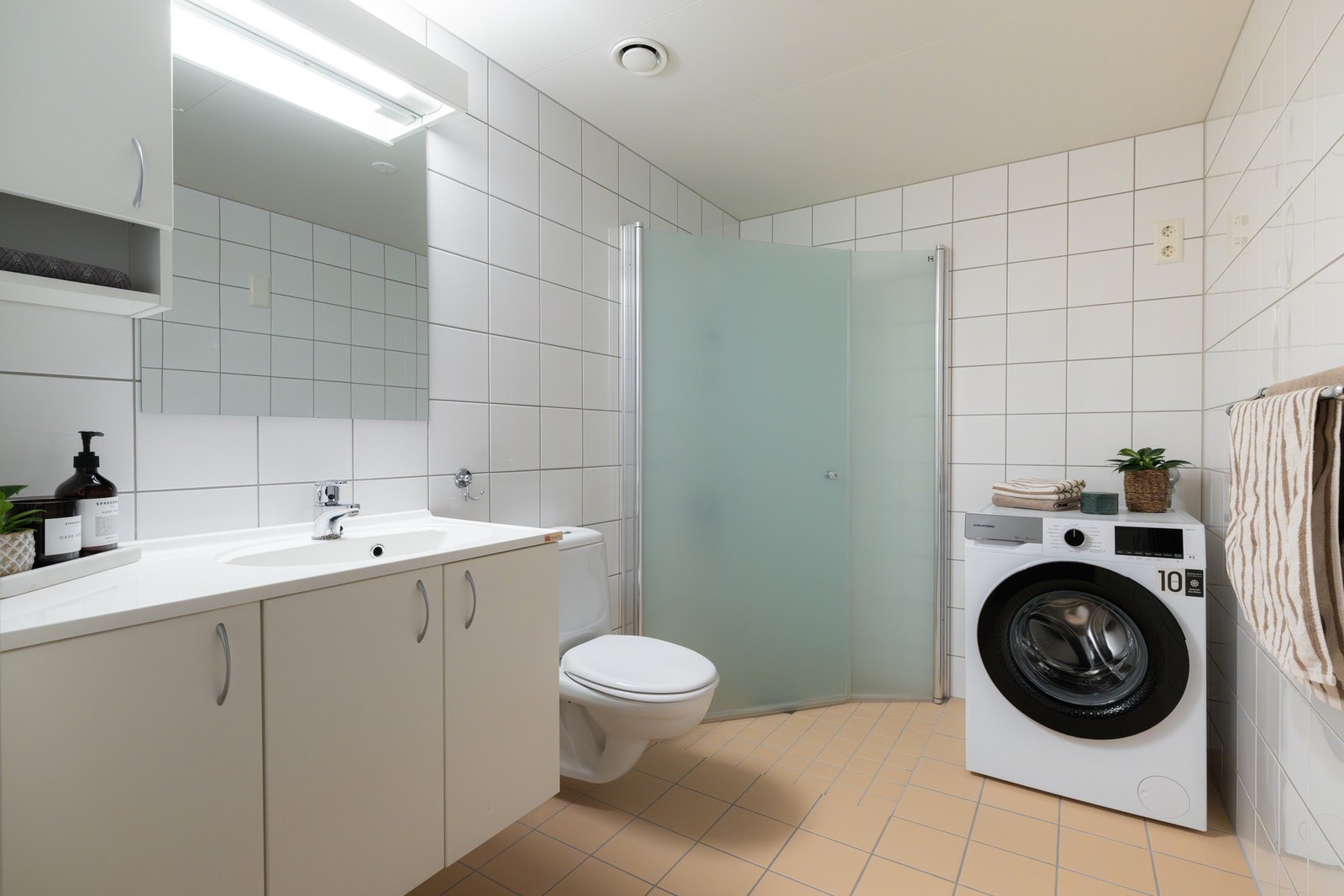 Boligens baderom er lyst flislagt med varme i gulv. Galleribilde