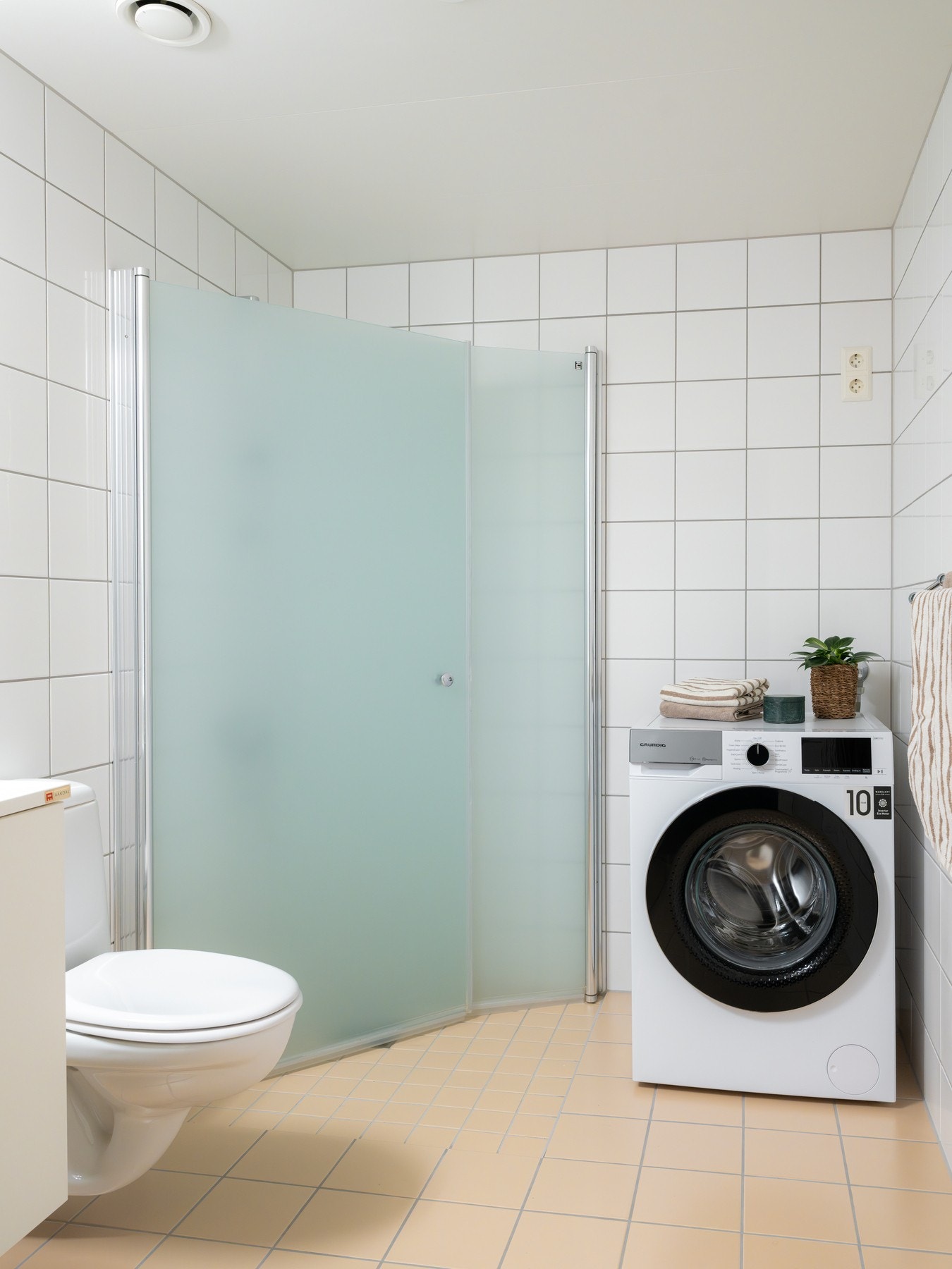 Innredningen består av vegghengt toalett og dusjhjørne med innfellbare glassdører som frigjør plass på gulvet. Opplegg for vaskemaskin. Galleribilde