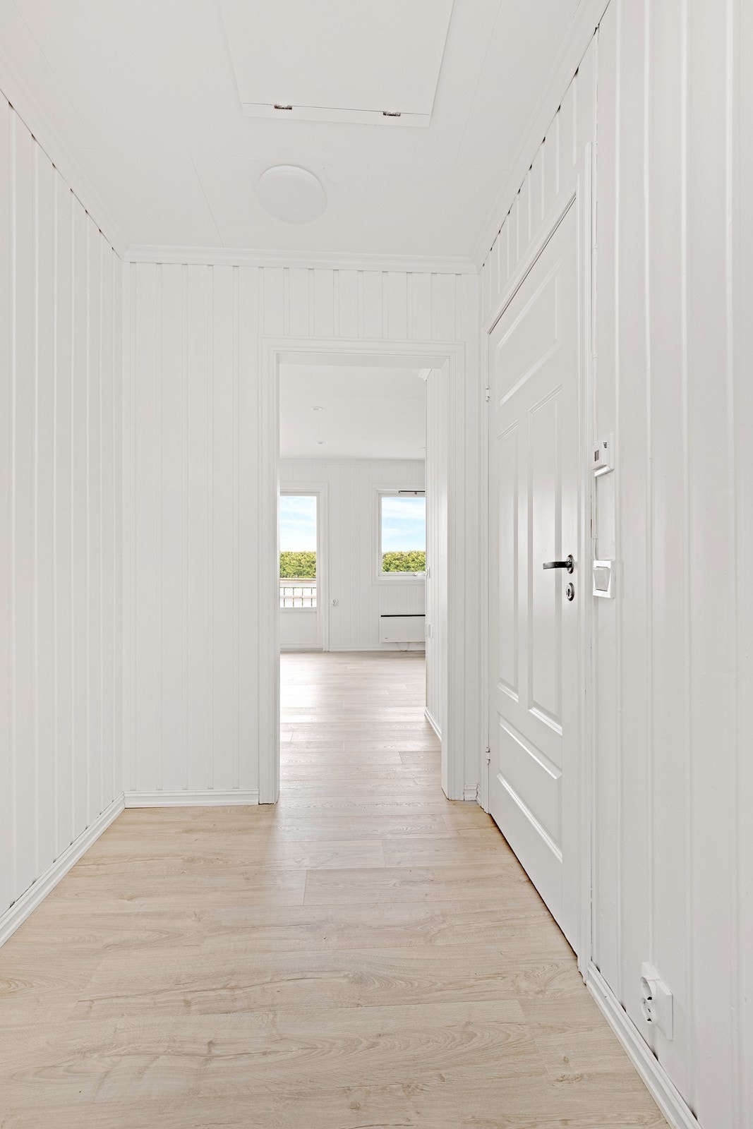 Laminatgulv og panelvegger gir en moderne entré med enkel tilgang til stue. Galleribilde