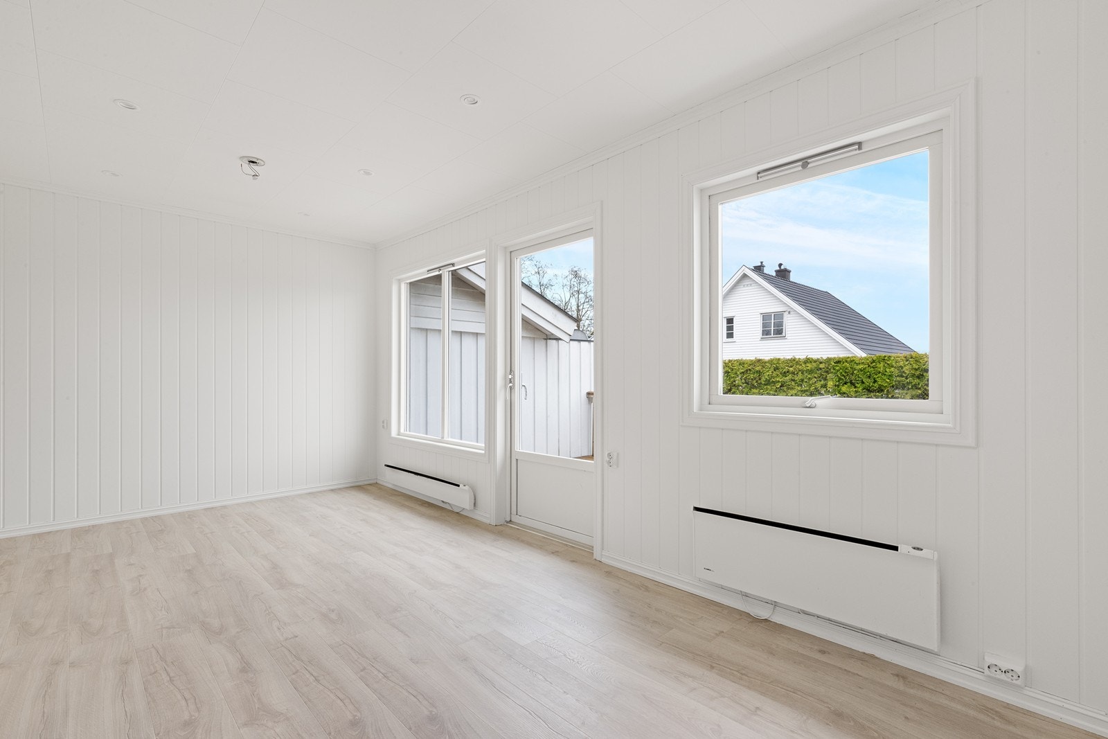 Store vinduer og utgang til terrasse gir godt lysinnslipp og enkel tilgang til uteområdet fra stuen. Galleribilde