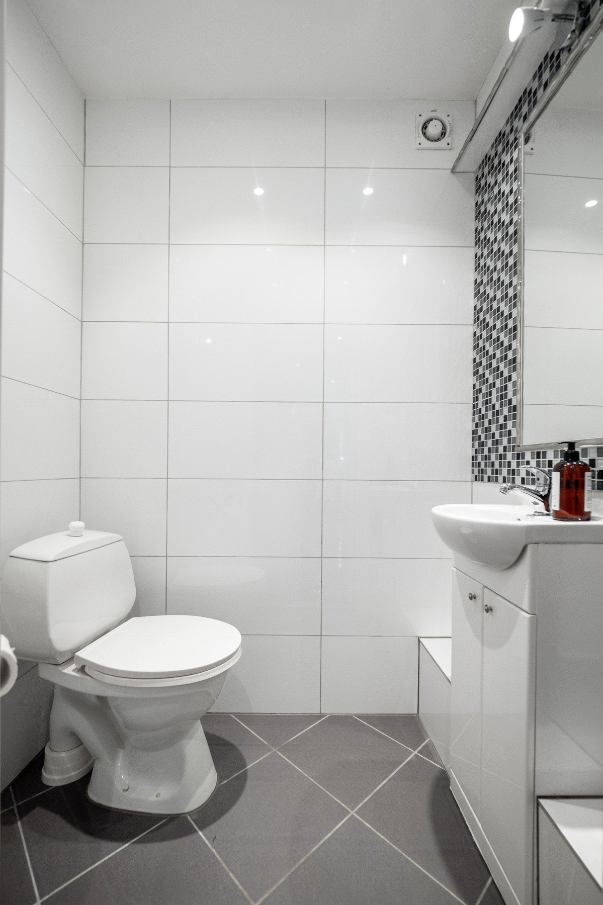 På wc-rommet er det hvite fliser på veggene, downlights i himlingen og grå fliser på gulvet. Galleribilde