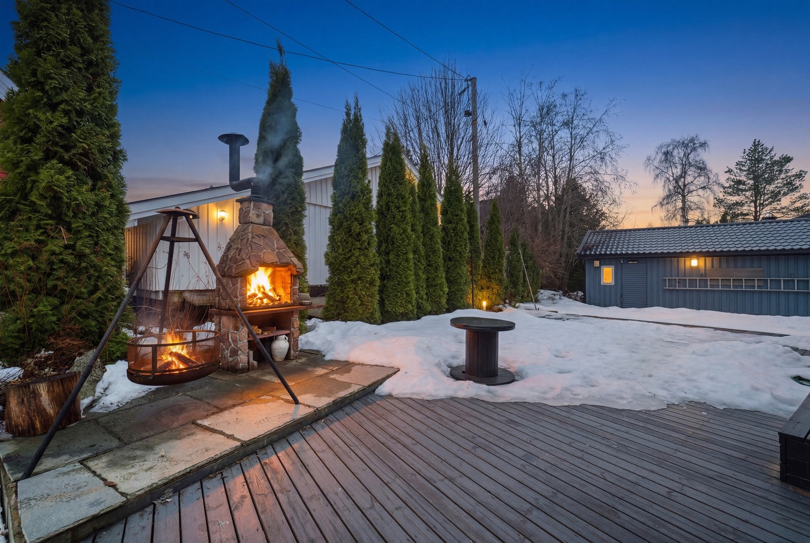 Ved den store terrassen er det et steinbelagt område med en oppmurt utepeis. Galleribilde