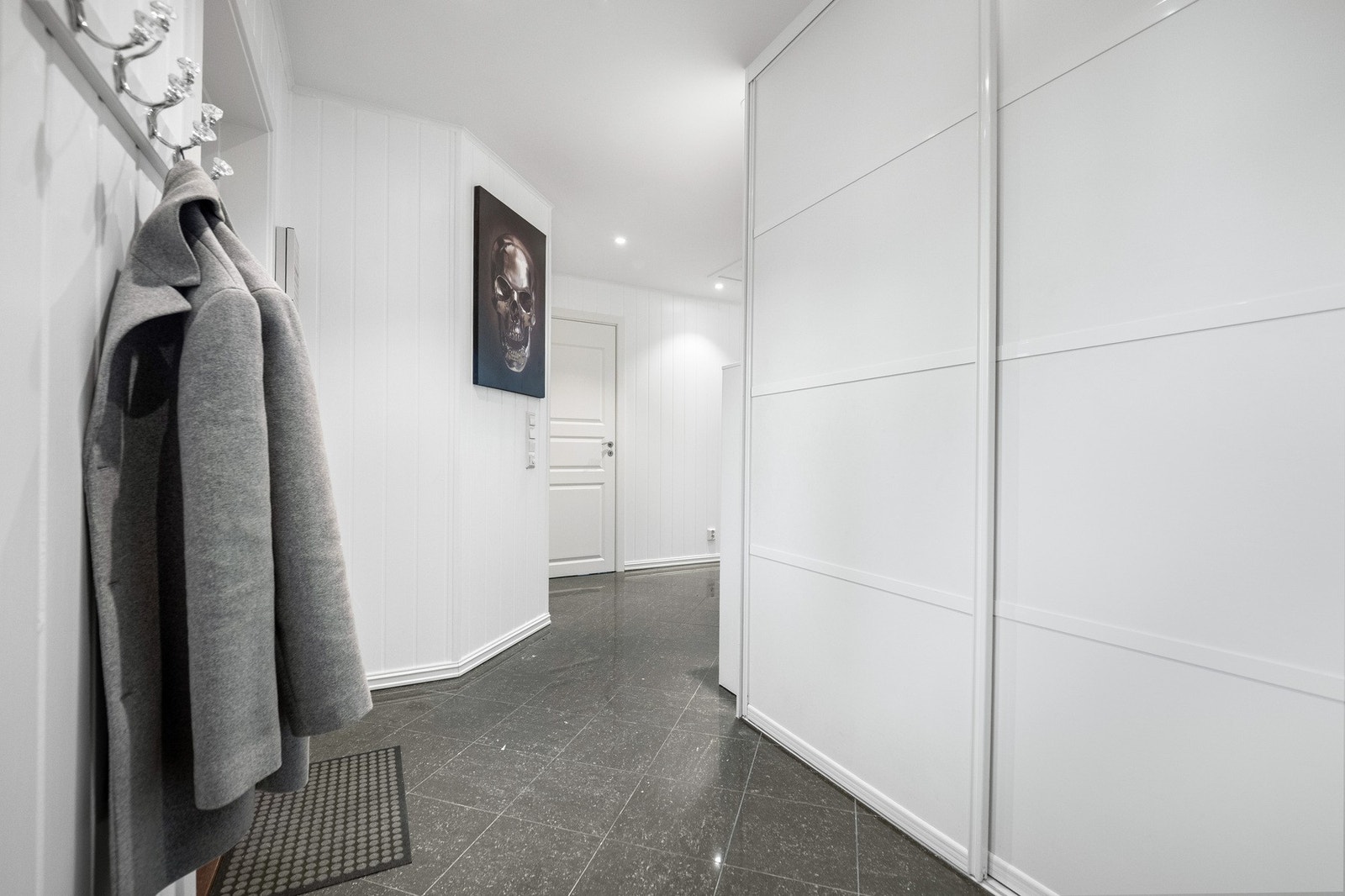 Yttertøy, sko og utstyr ryddes enkelt bort i en bred, plassbygd skyvedørsgarderobe i entreen. Galleribilde