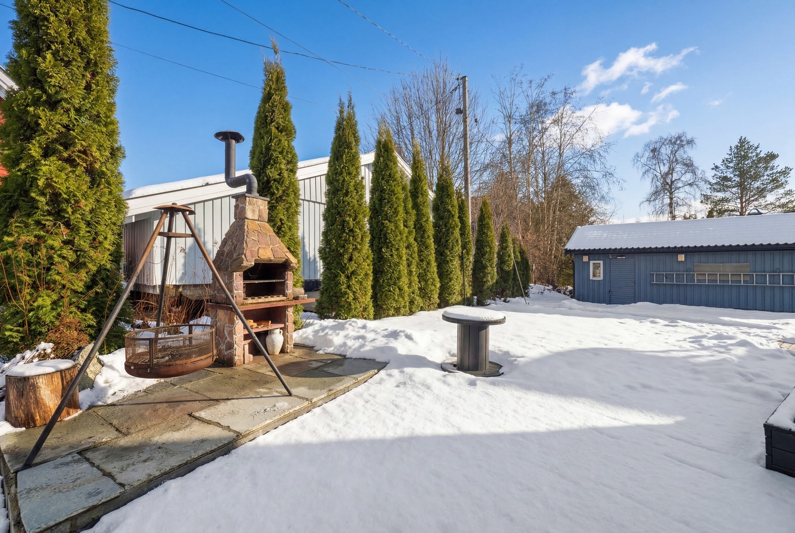 På et hellelagt område av terrassen er det en oppmurt utepeis. Galleribilde