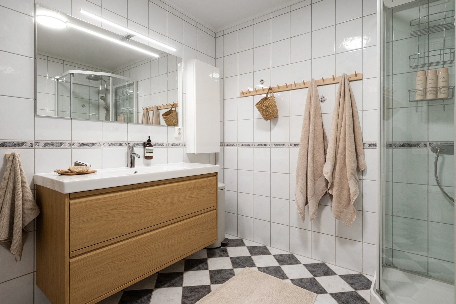 Lyst og fint bad med fliser på gulv med elektrisk gulvvarme, flislagte vegger og takessplater i innvendig tak. Galleribilde