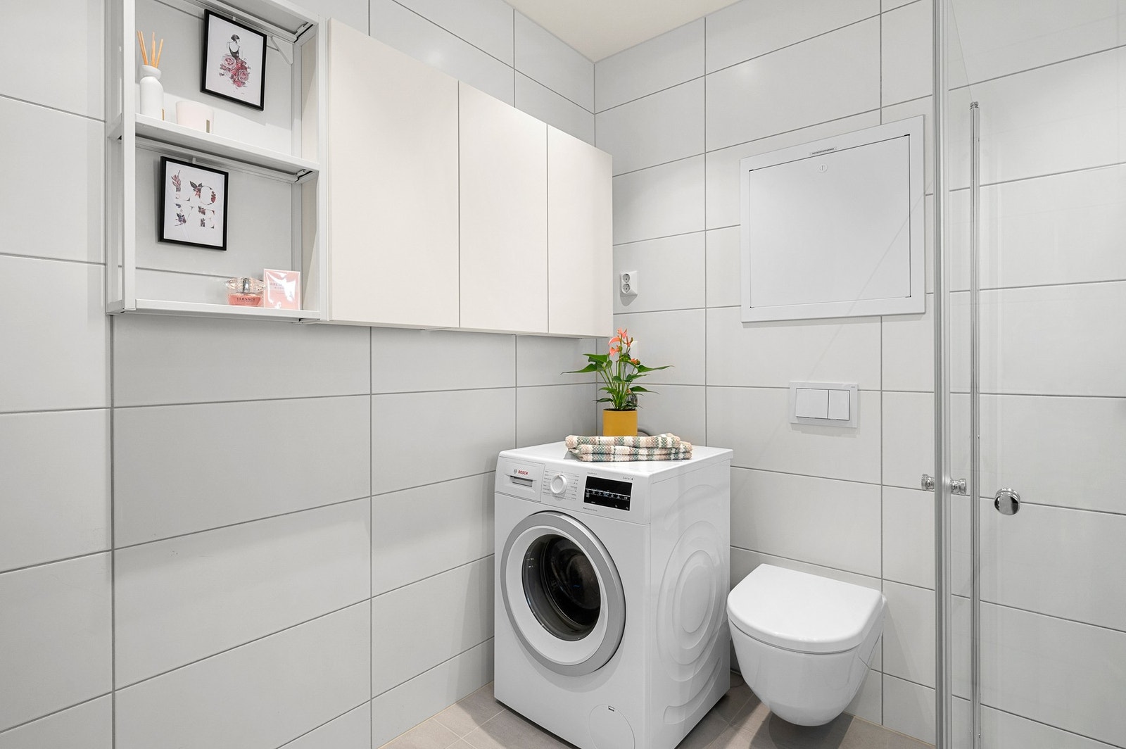 Badet er utstyrt med gulvvarme, vegghengt WC, mekanisk avtrekk, opplegg for vaskemaskin og god oppbevaring i skap og brede skuffer under servanten. Galleribilde