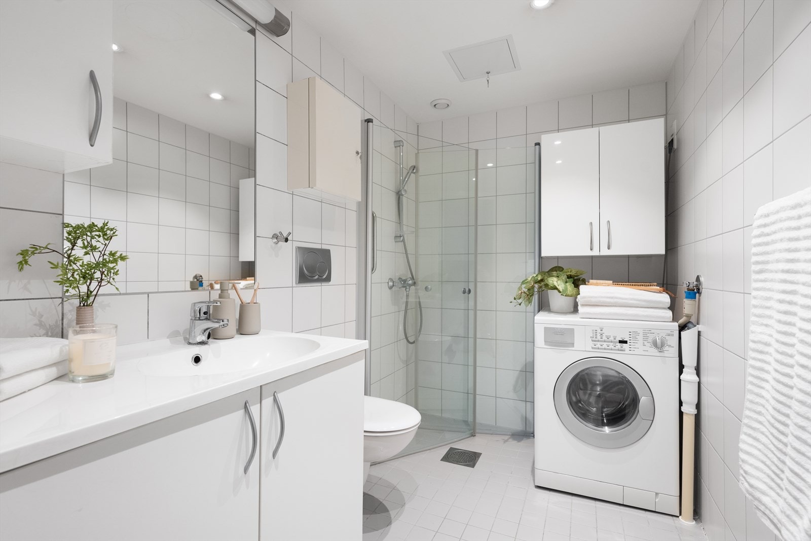 Badet er kombinert med vaskerom og har flislagte overflater og varme i gulvet. Galleribilde