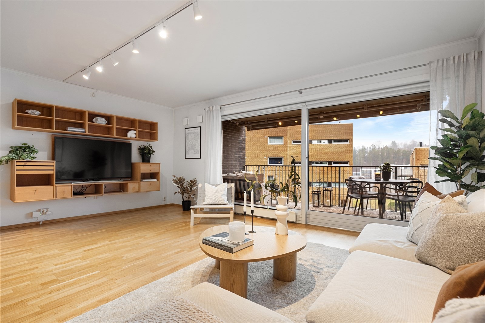 Stuen, spisestuen og kjøkkenet har parkett på gulv, malte veggflater og betonghimling. Galleribilde