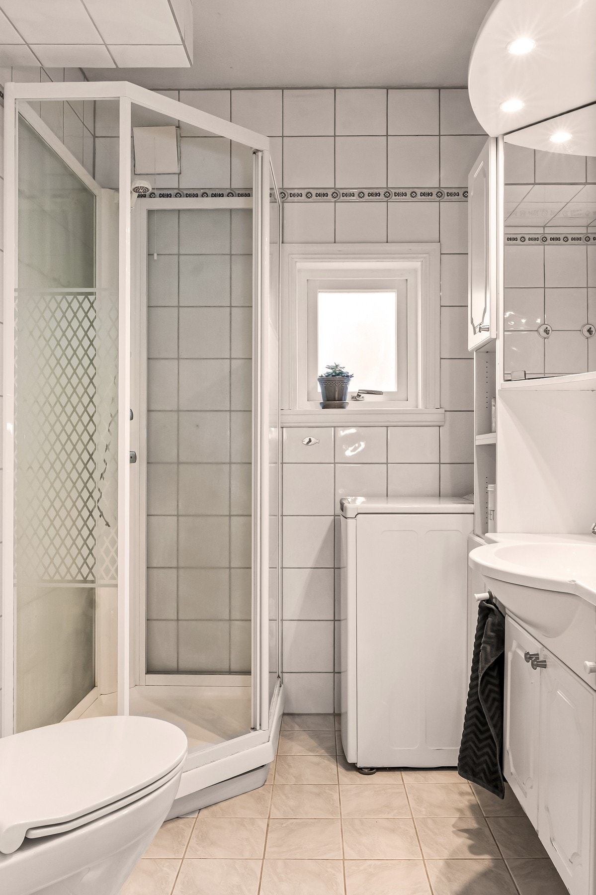 Badet har fliser på vegger og gulv Galleribilde