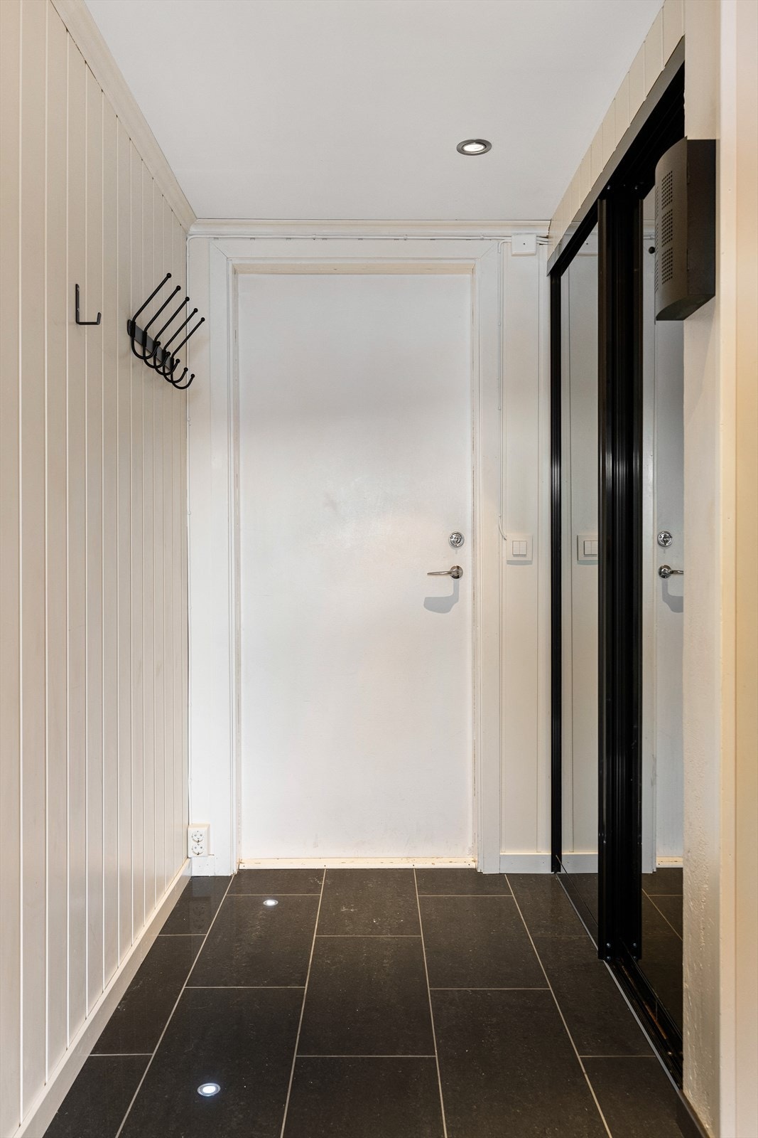 Flislagt entré med skyvedørsgarderobe. Galleribilde