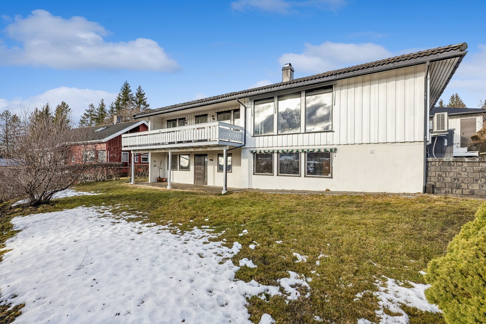 Tomten er opparbeidet med plen og hekk, og ligger i et skrånende terreng. Galleribilde