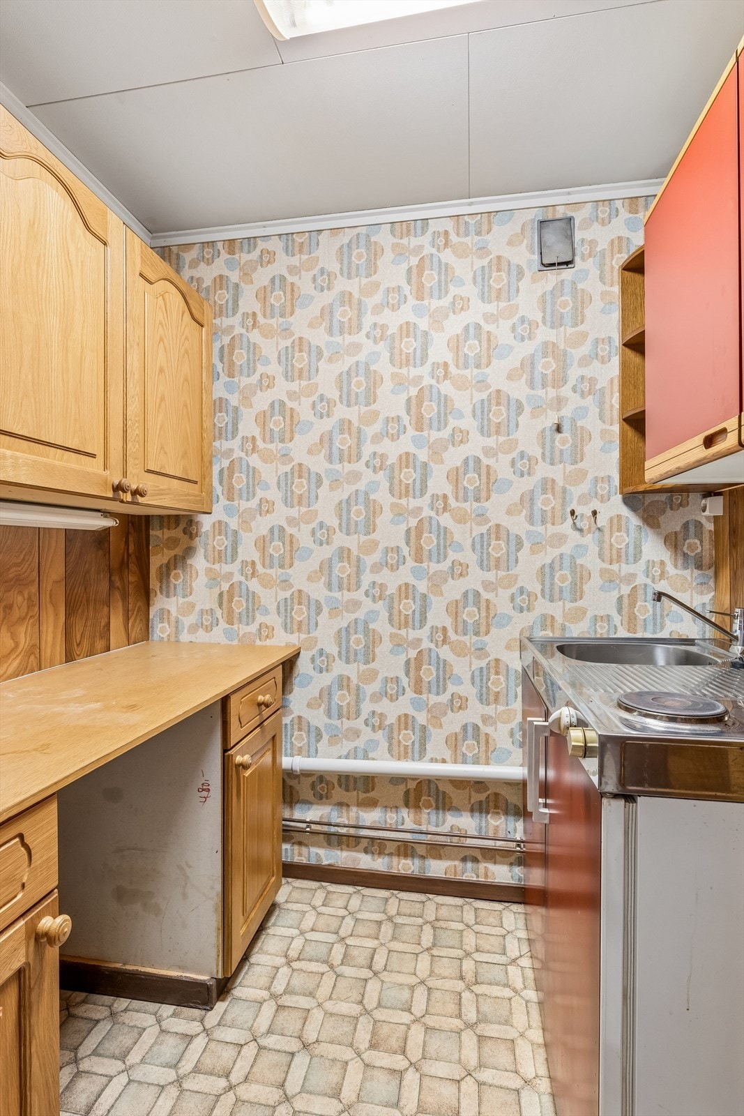 Et annet innredet rom med en enkel hybelkjøkkenløsning. Bruksendringen fra bod er ikke omsøkt. Galleribilde