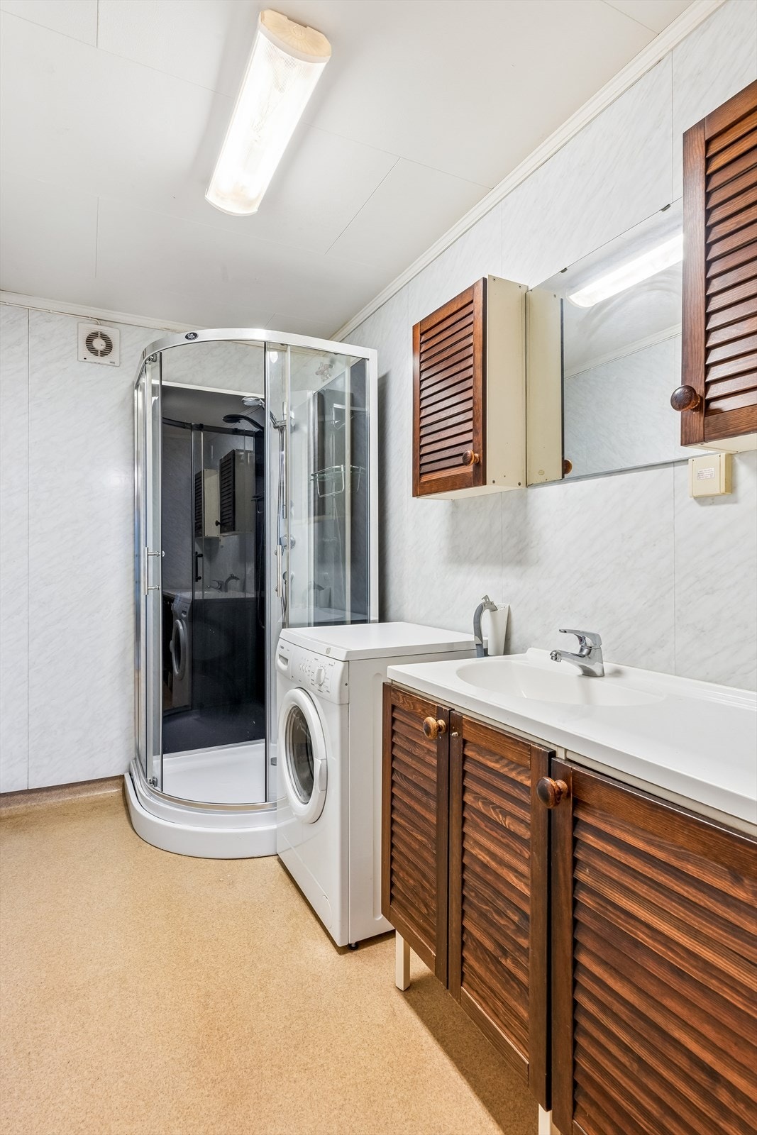 Kombinert bad og vaskerom i underetasjen med varmekabler, dusjkabinett og opplegg for vaskemaskin. Galleribilde