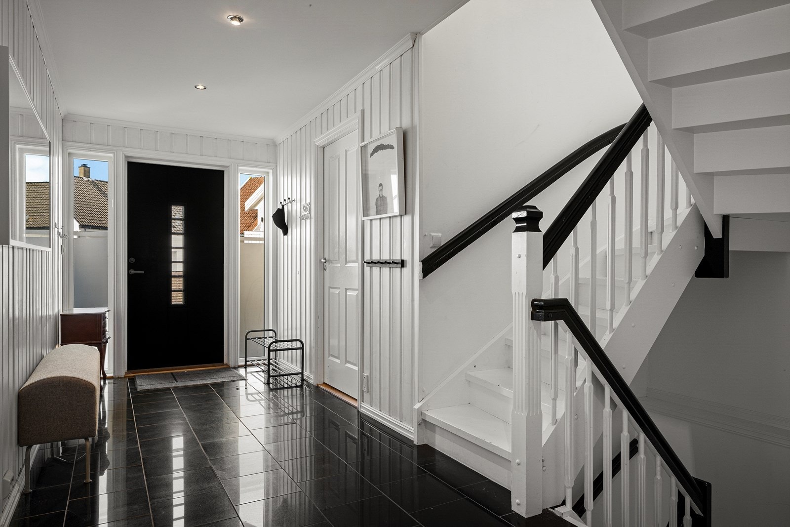 Romslig entré med trappeforbindelse til boligens øvrige etasjer. Det er vannbåren varme i gulvet. Galleribilde