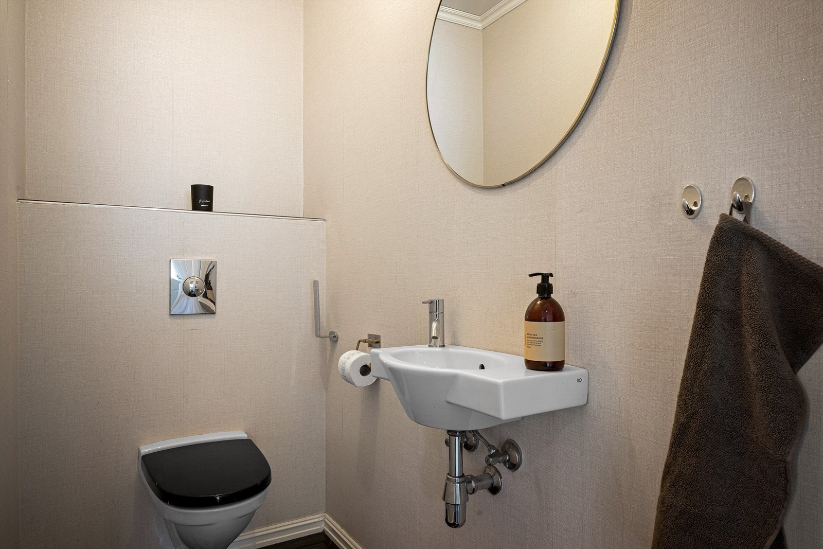 Praktisk toalettrom i første etasje med vegghengt toalett, servant og flislagt gulv med varme. Galleribilde