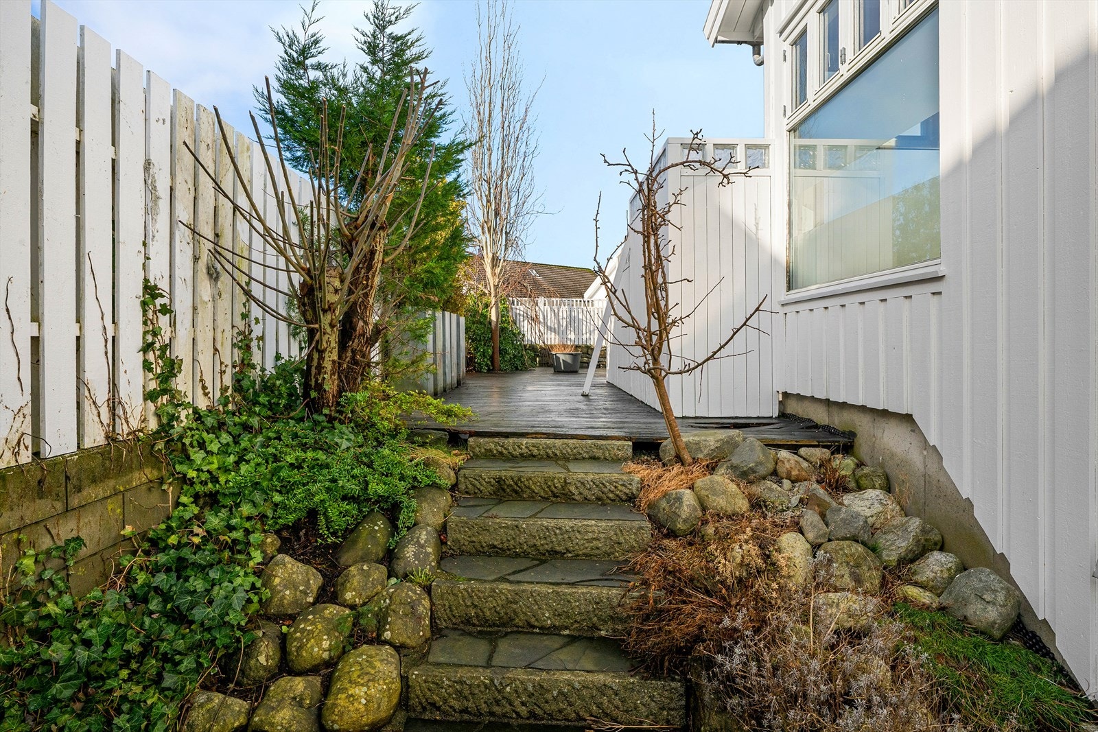 Tomten er opparbeidet med trapper i naturstein og beplantning. Galleribilde