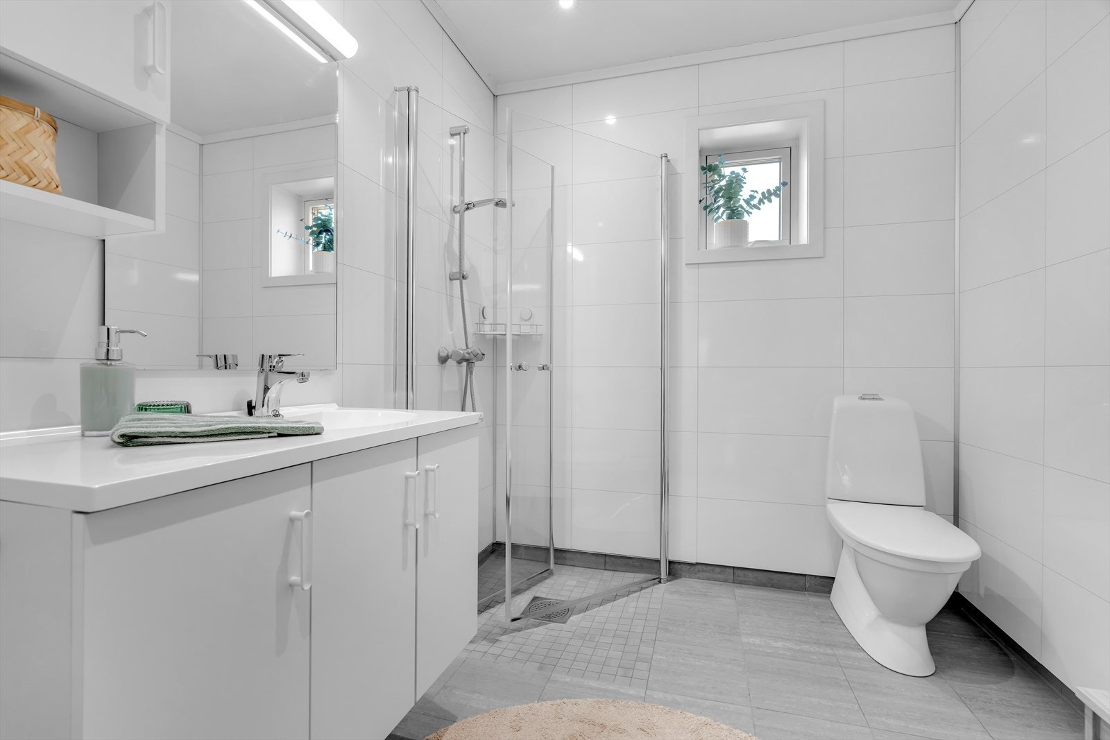 Badet er innredet med nedfelt servant, toalett, dusjhjørne med dusjvegger, samt opplegg for vaskemaskin. Galleribilde