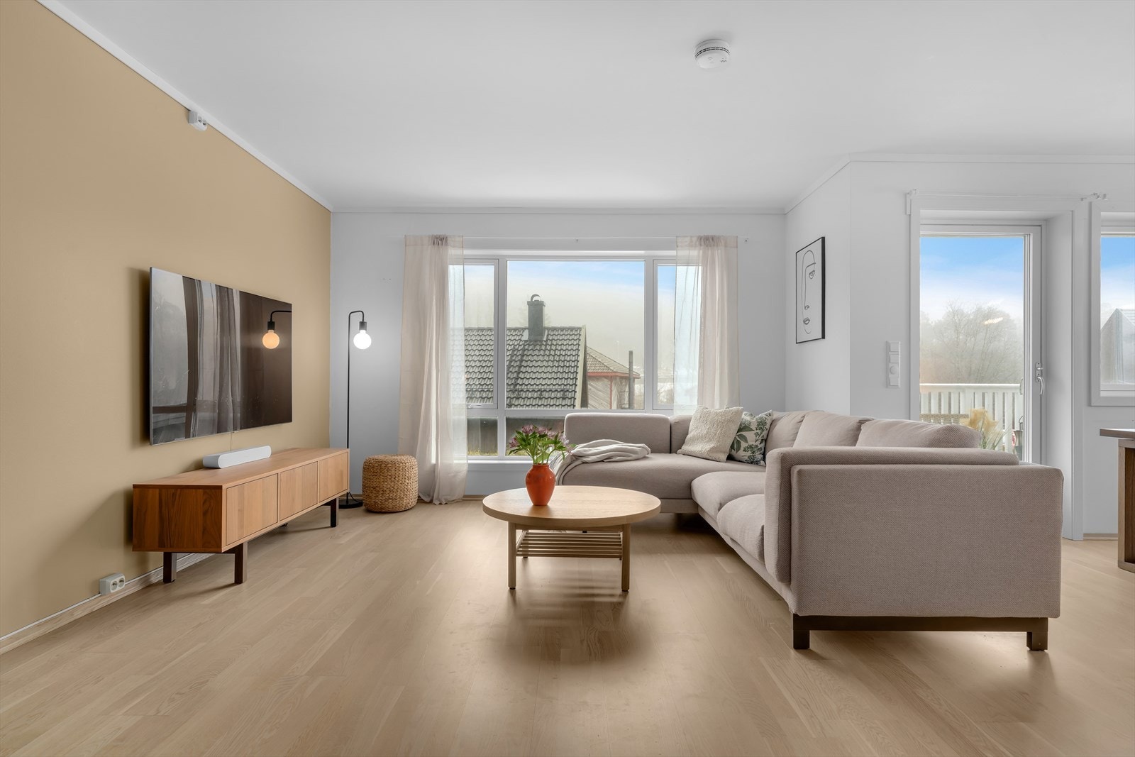 Store vinduer og utgang til balkong sørger for rikelig med naturlig lys i rommet. Galleribilde