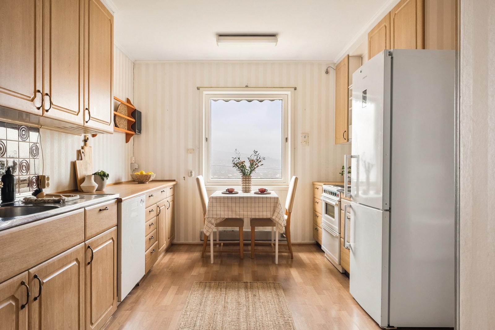 Kjøkken med laminatgulv og praktisk innredning med profilerte fronter. Galleribilde