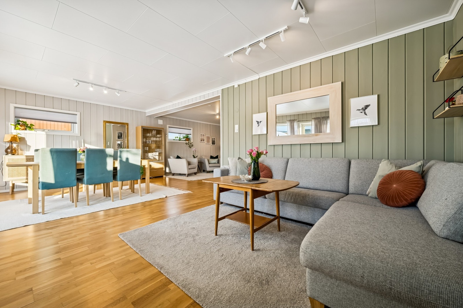 Romslig stue med plass til både sofa, spisebord og egen sittegruppe - en praktisk løsning for familier som trenger flere soner i hverdagen Galleribilde