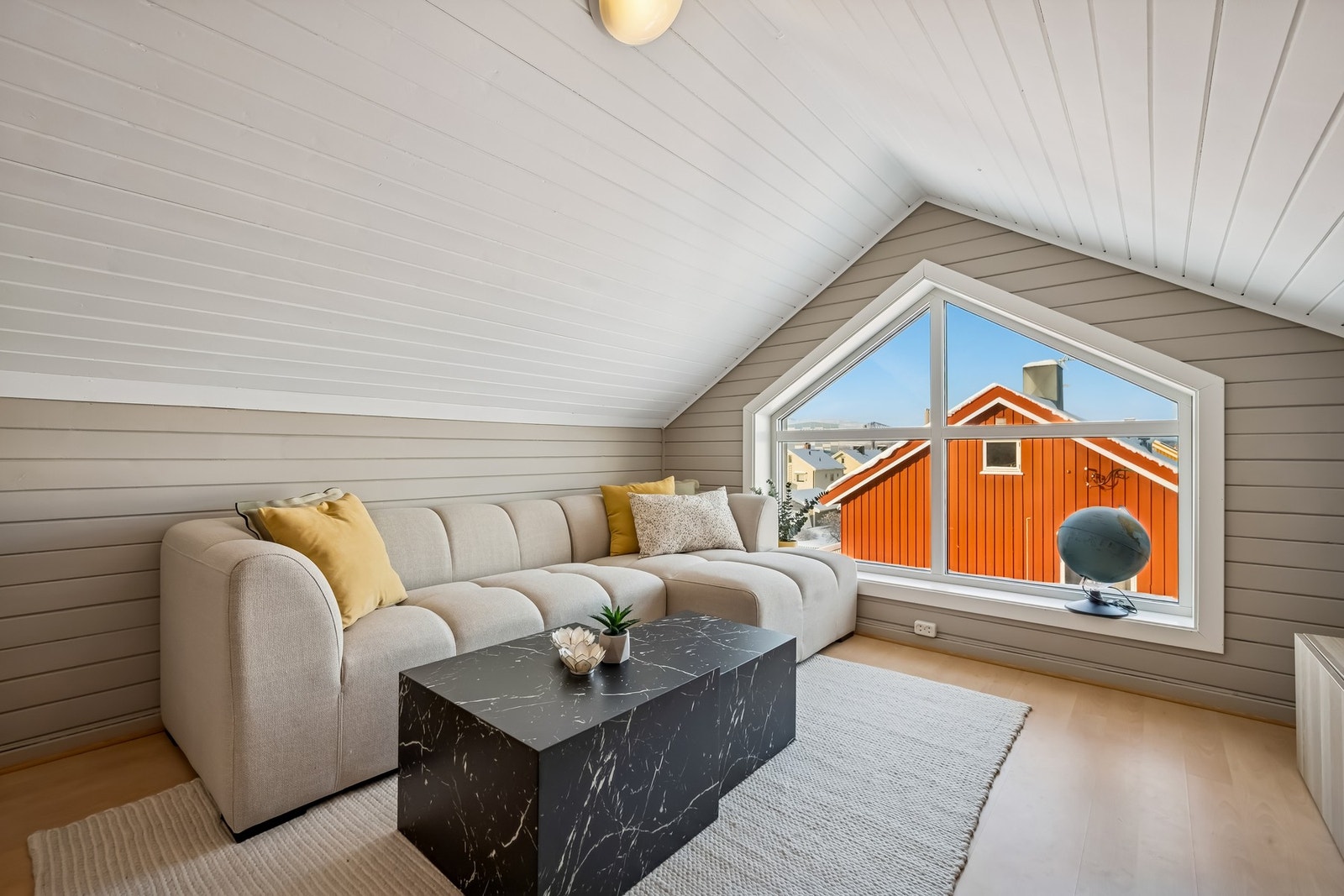 Innbydende loftstue med skråtak og store loftsvinduer som skaper en lys og åpen atmosfære Galleribilde