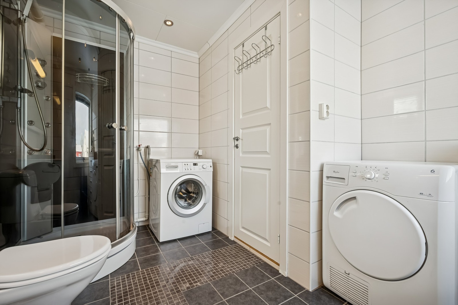 Badet har flislagt gulv med varme Galleribilde